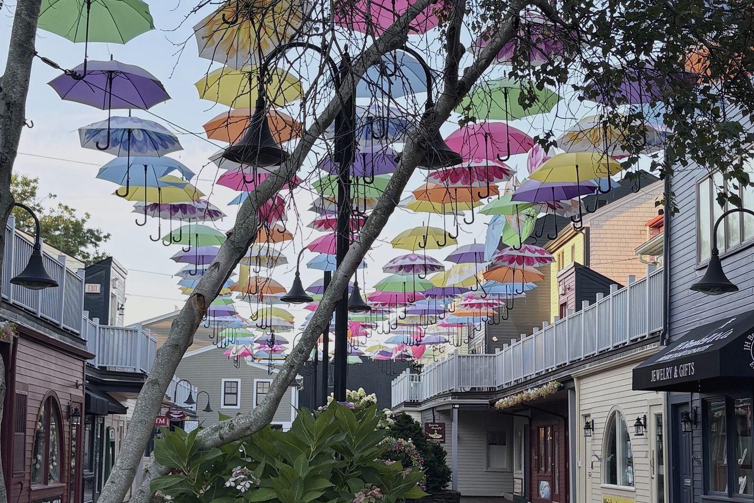 A canopy of coloured umbrellas strung above a brick lane in Newport